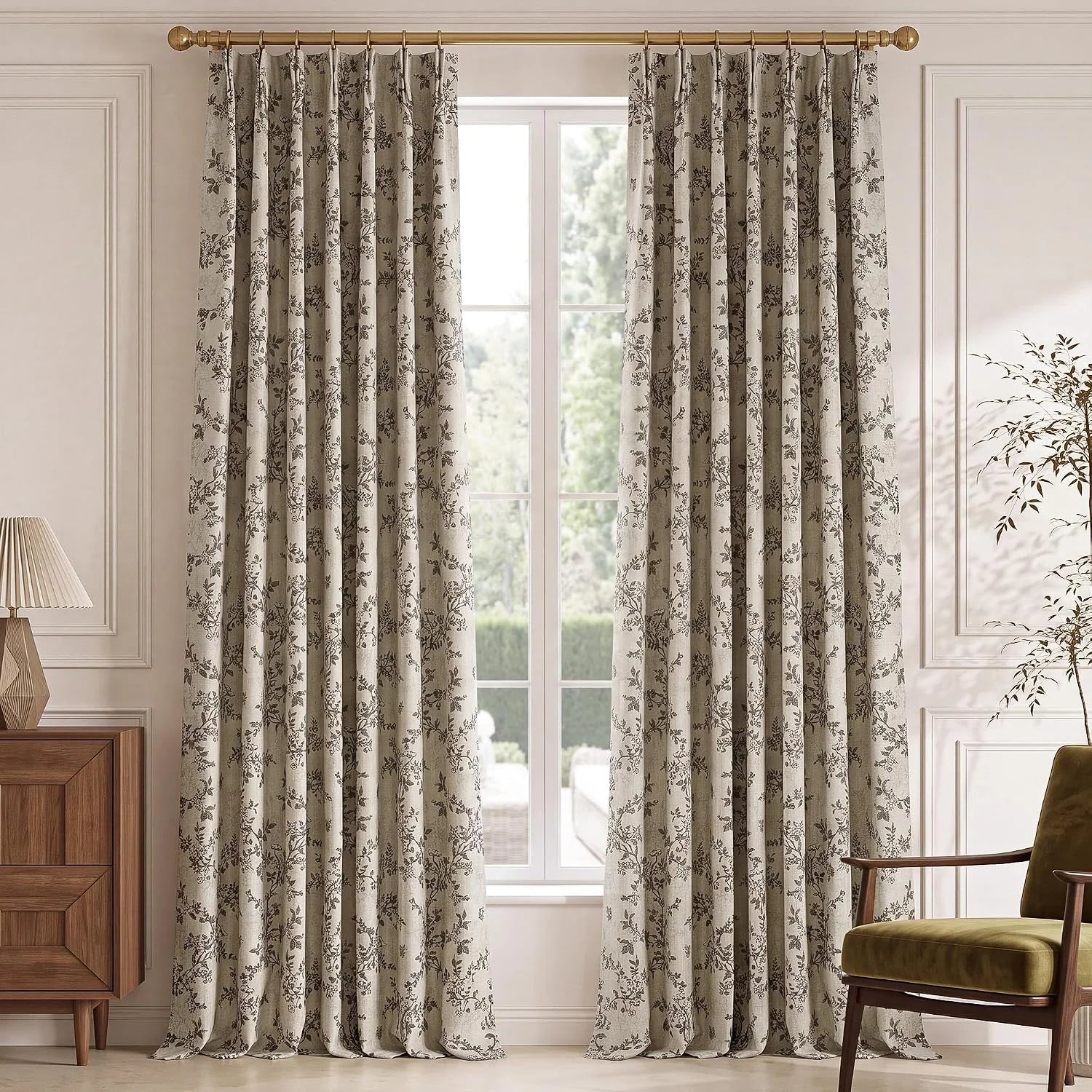 Beige botanical print curtains on a brass rod in a bright classic living room