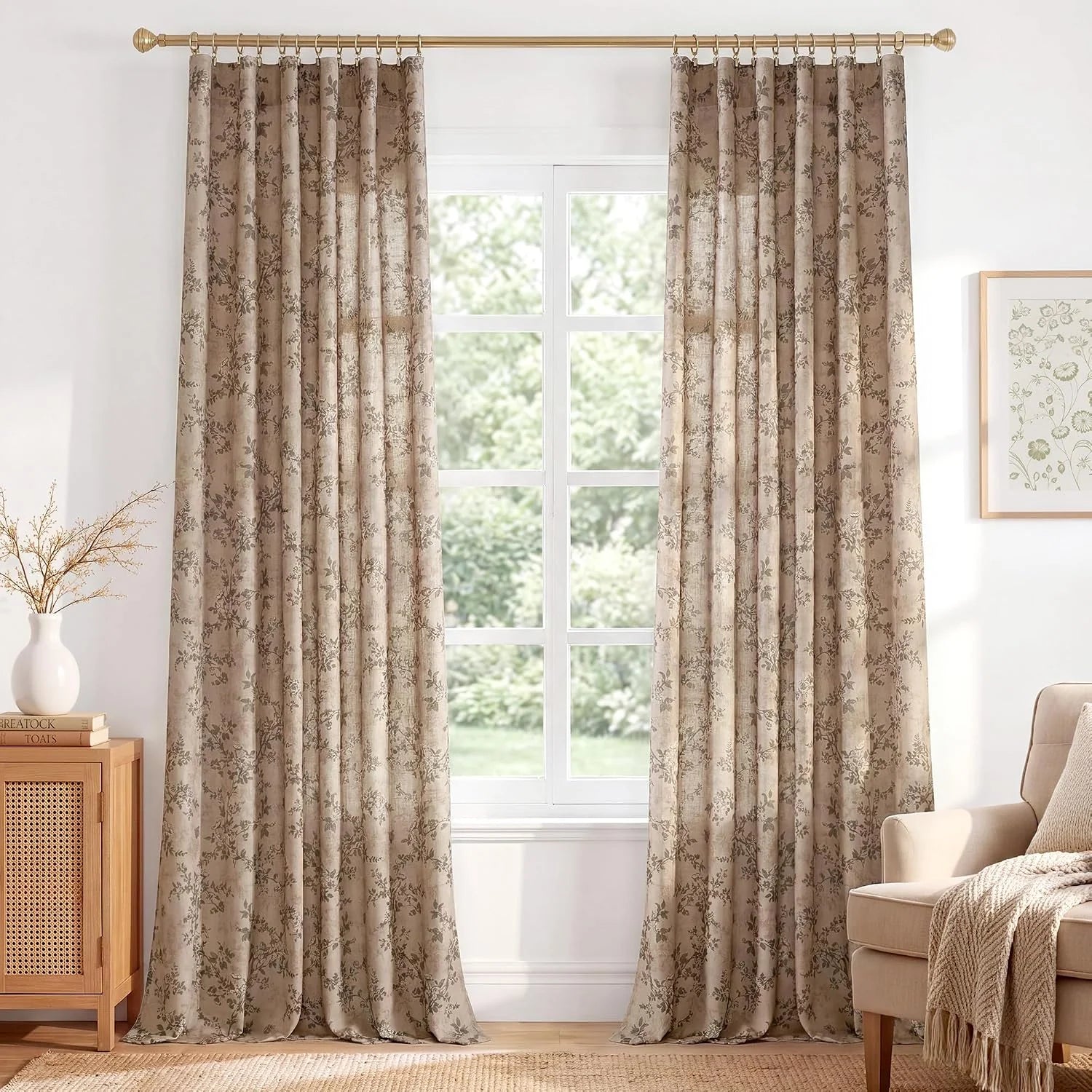 Beige floral patterned curtains hanging on a brass rod in a bright cozy living room