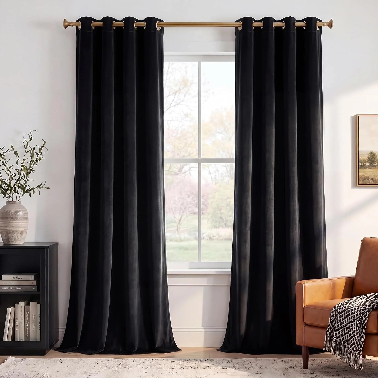 Black velvet grommet curtains on a gold rod in a bright modern living room
