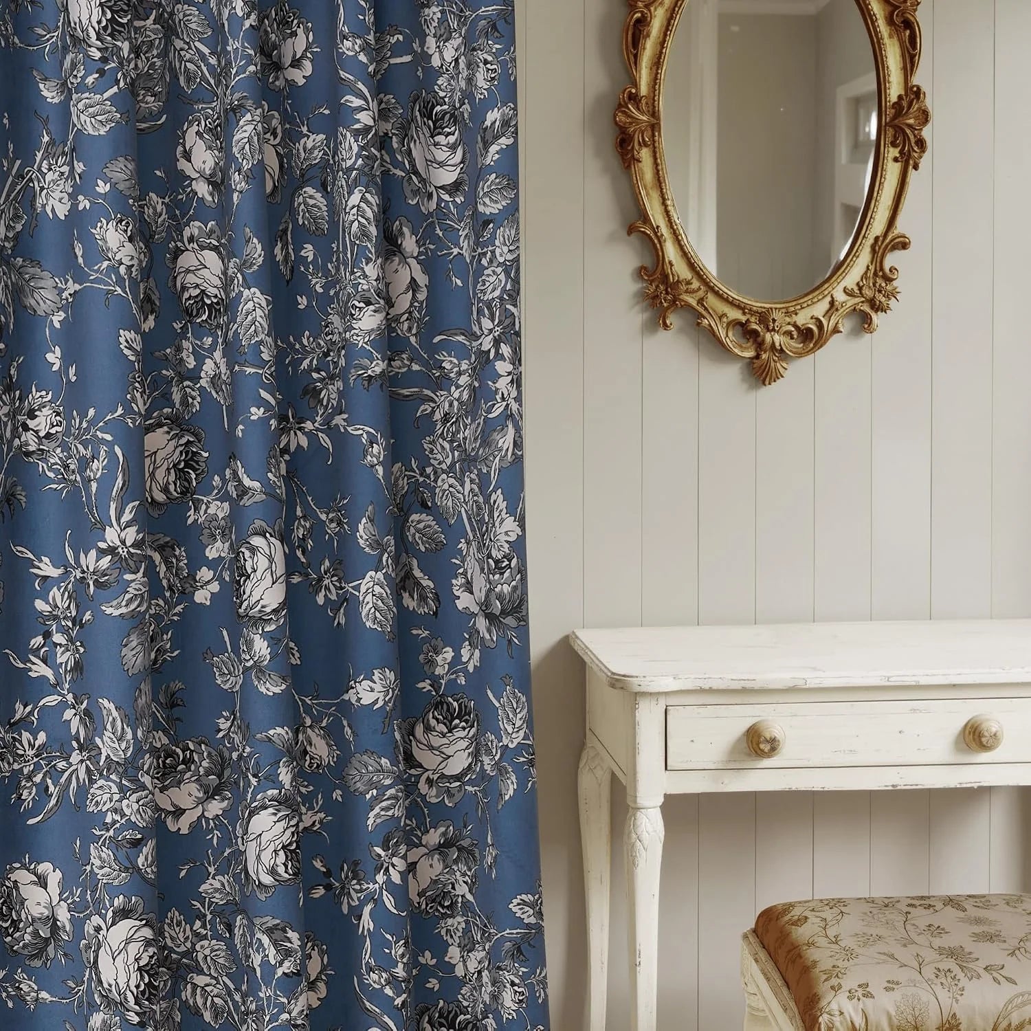 Blue curtain panel with black and white floral print beside a vintage vanity