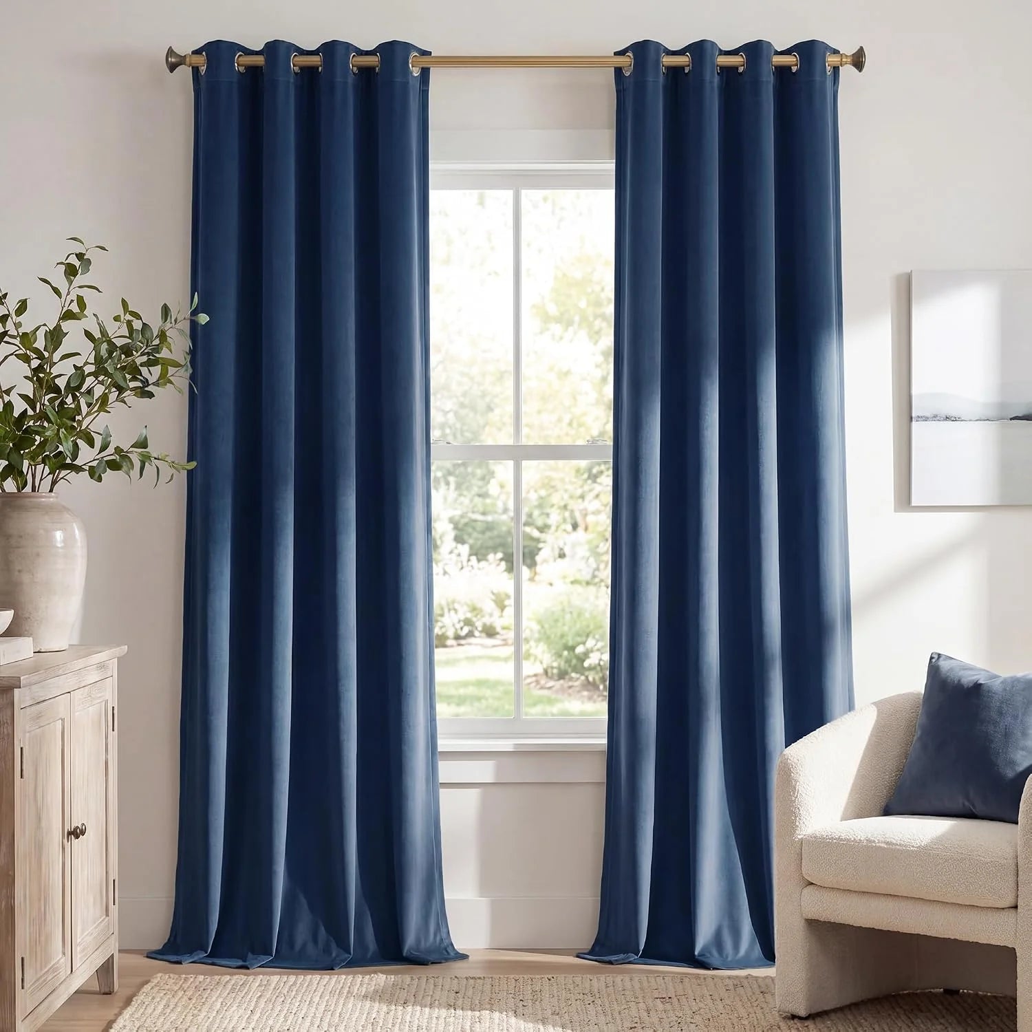 Blue velvet grommet curtains hanging in a bright modern living room window