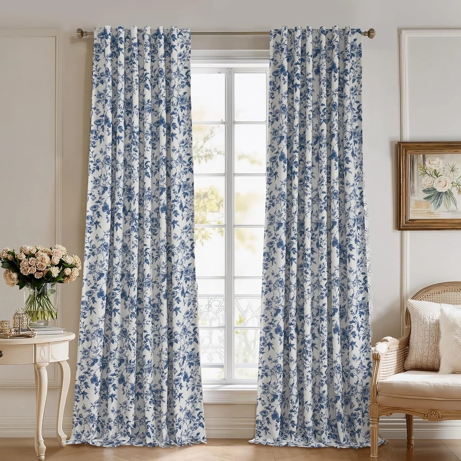 Blue and white floral curtains hanging in a bright classic bedroom window