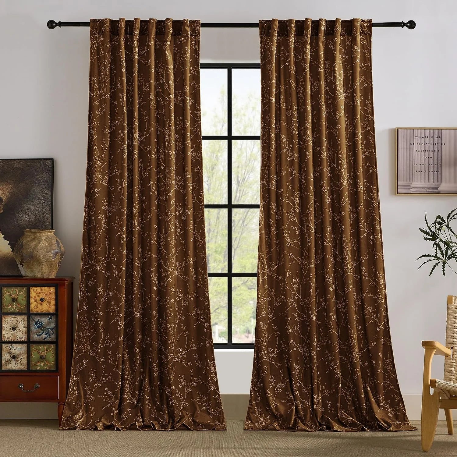 Brown botanical print curtains hanging on a black rod in a cozy living room