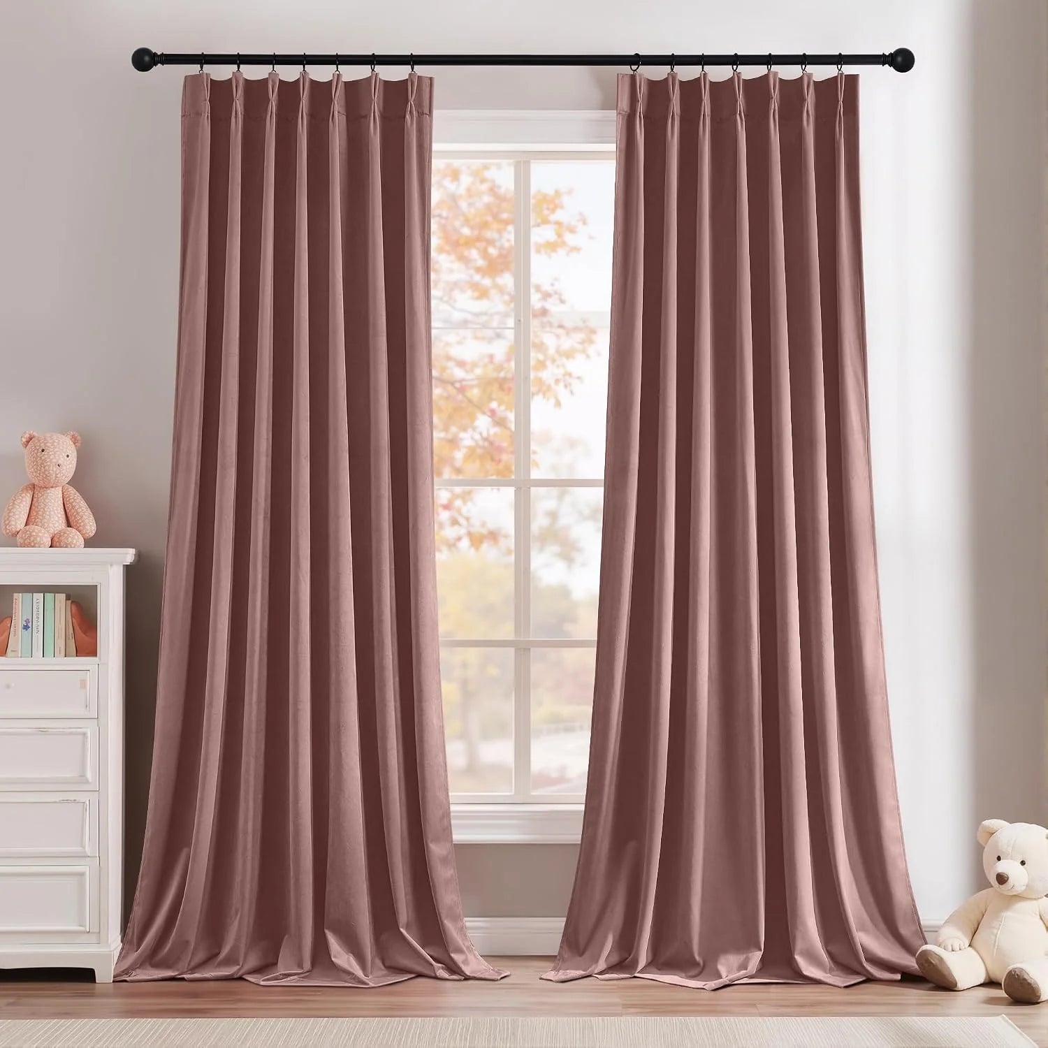 Dusty rose velvet curtains on a black rod in a soft, neutral kids bedroom