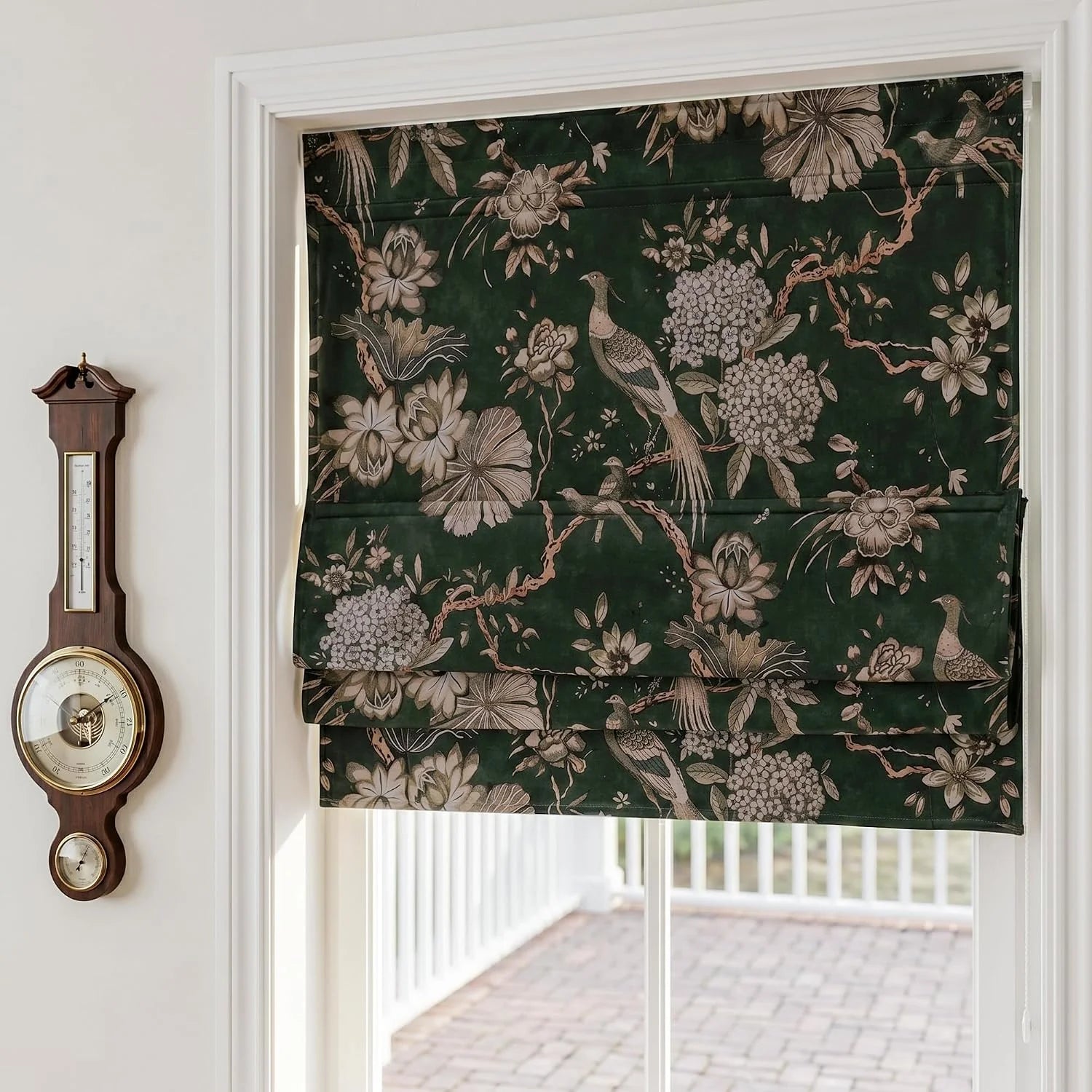 Dark green Roman blind with bird and floral print on a white framed window