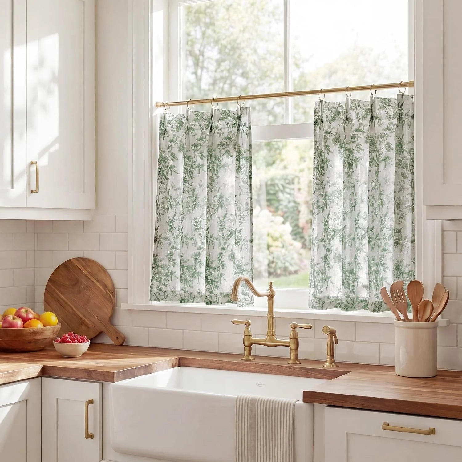 Green botanical sheer cafe curtains on a brass rod above a bright farmhouse sink