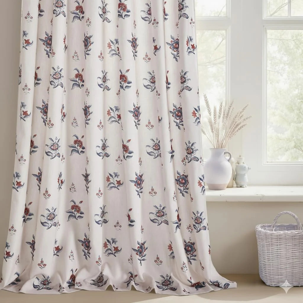 Ivory curtain with blue and rust floral print beside a bright window