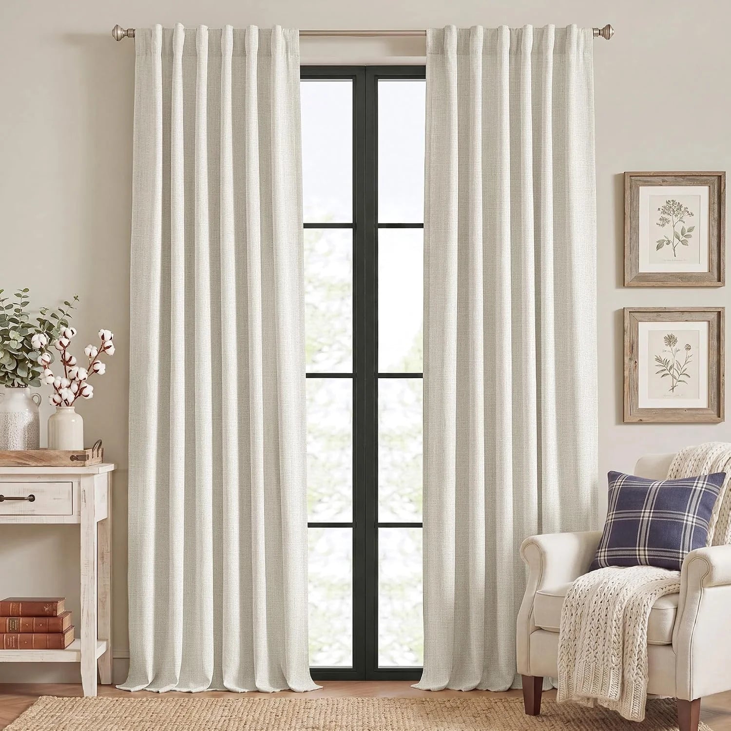 Ivory linen-look pleated curtains on a black window in a cozy neutral living room