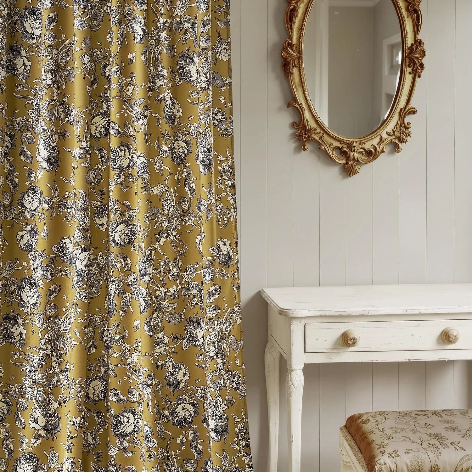 Mustard floral curtain panel beside a vintage white vanity and ornate gold mirror