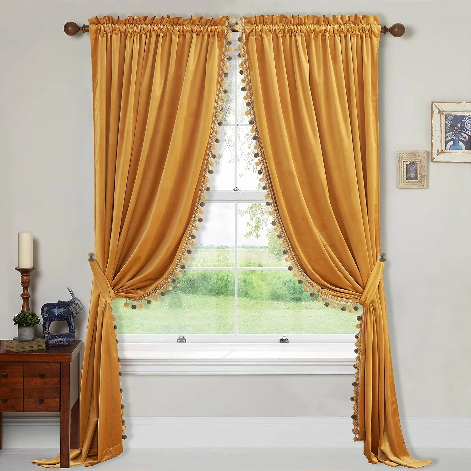 Mustard velvet curtains with pom-pom trim and tiebacks over a bright window