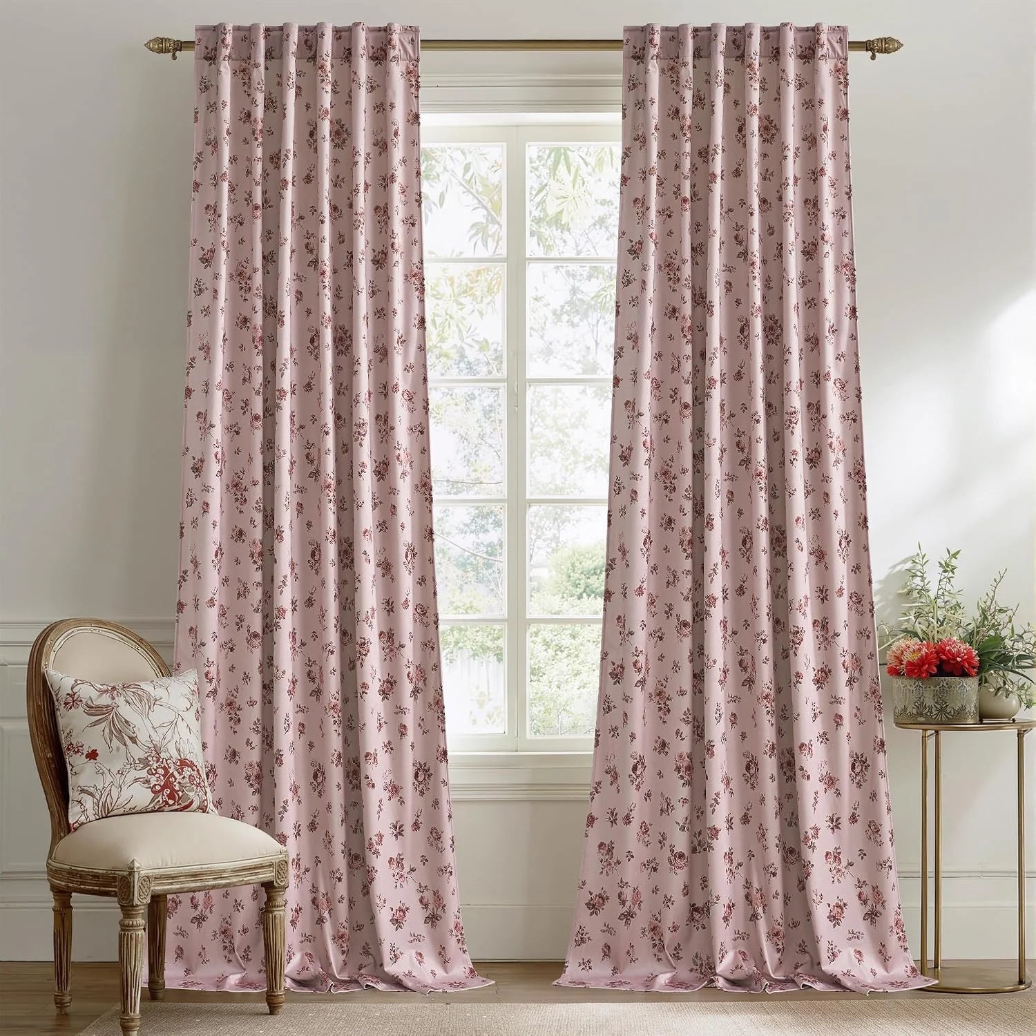 Soft pink floral curtains hanging in a bright traditional room with vintage decor