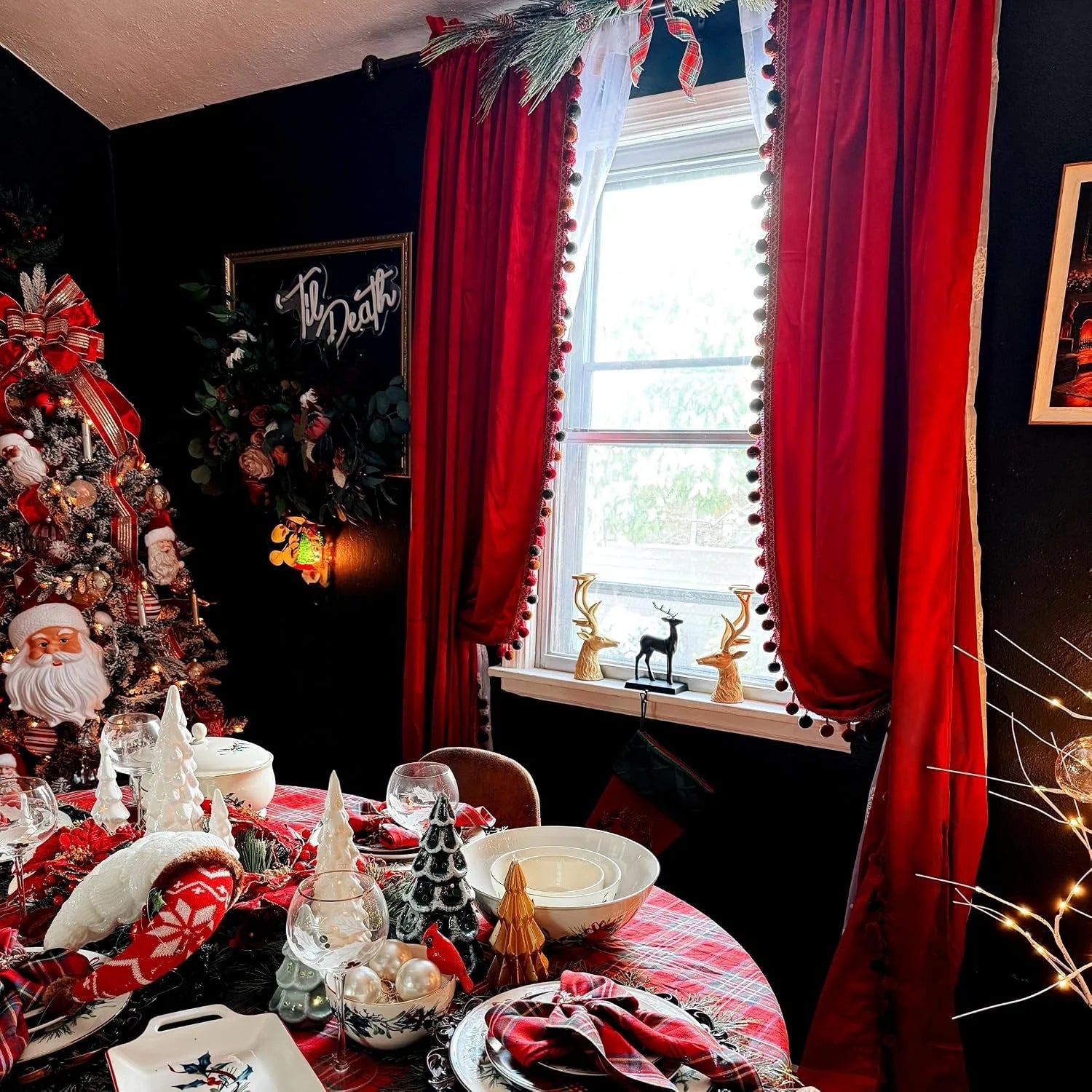 Red velvet curtains with pom-pom trim in a dark festive dining room window