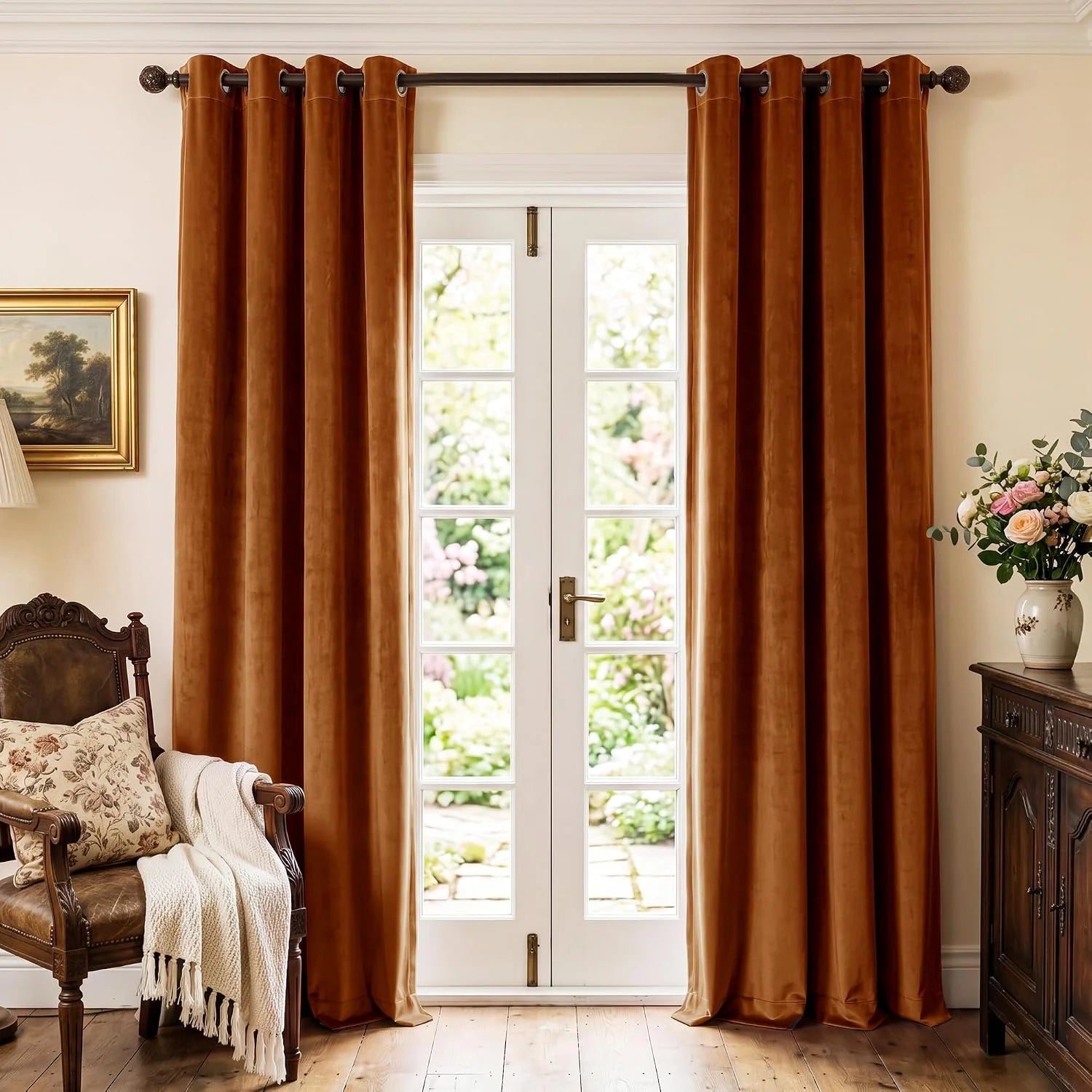 Rust velvet grommet curtains hanging over white French doors in a classic room