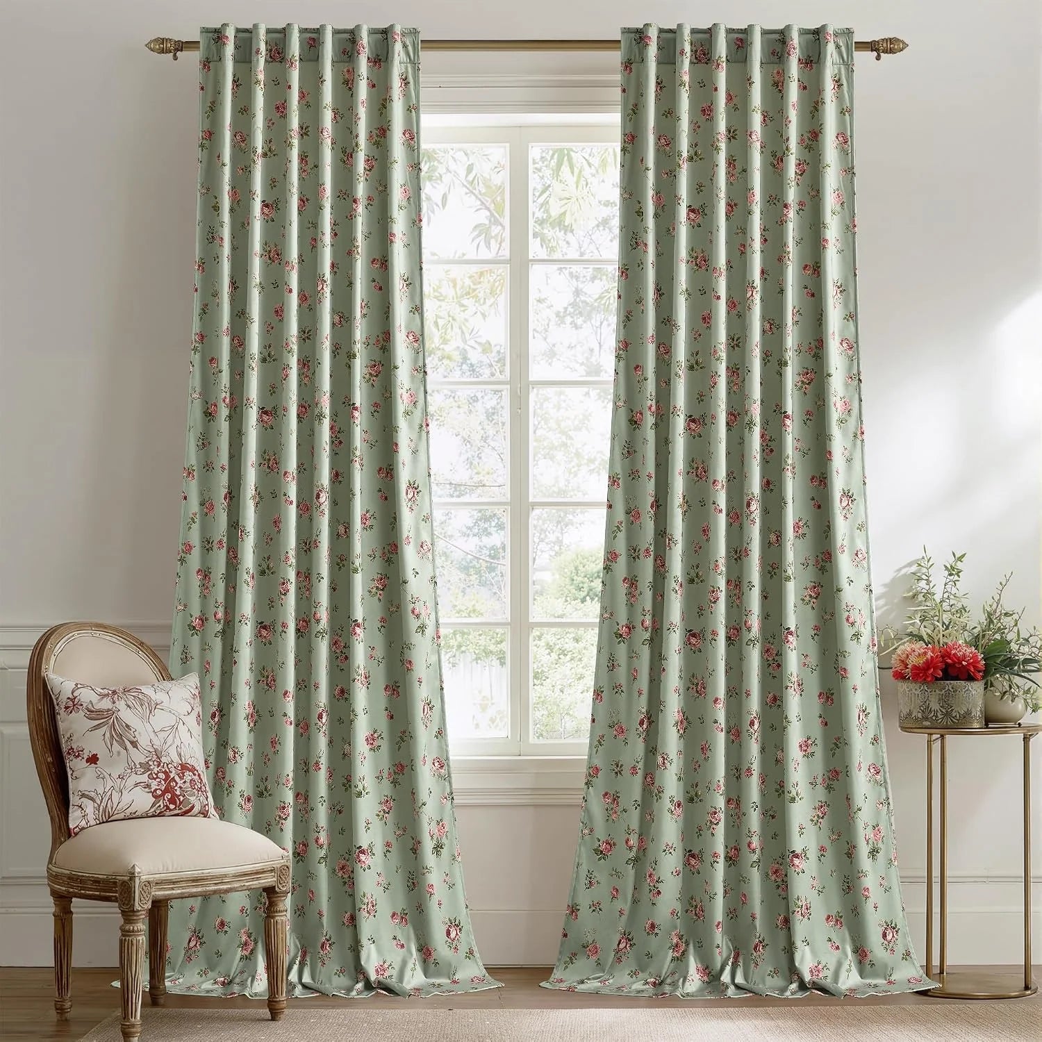 Sage green floral curtains hanging on a brass rod in a bright vintage-style room