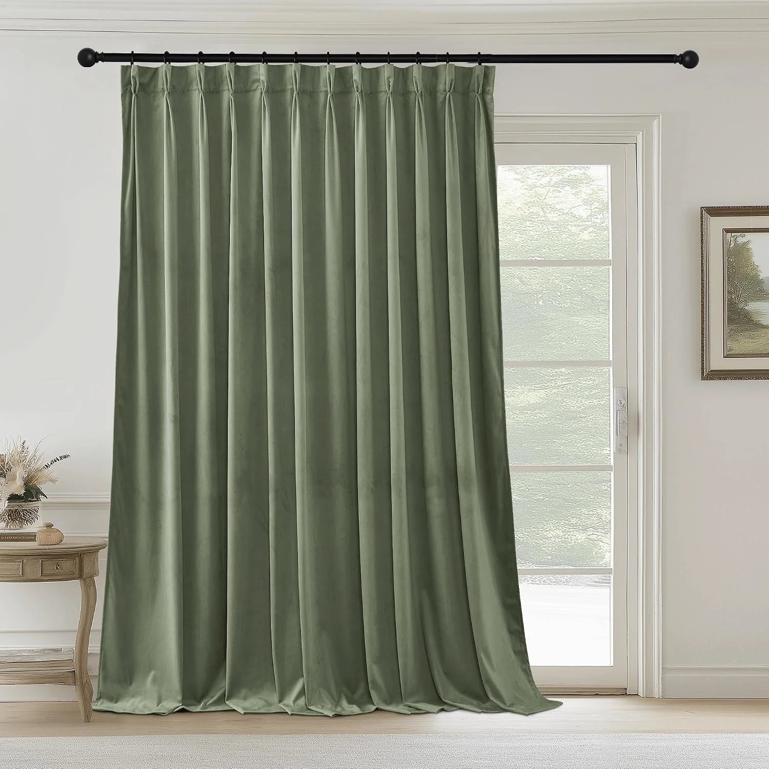 Sage green velvet pinch pleat curtain panel on a black rod beside a glass door