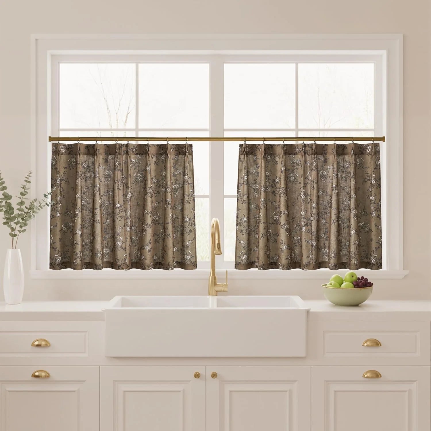 Taupe floral tier curtains on a brass rod above a white farmhouse kitchen sink