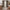 Taupe floral sheer curtains on a brass rod in a warm rustic living room