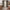 Taupe sheer floral curtains hanging on a rod in a warm rustic living room